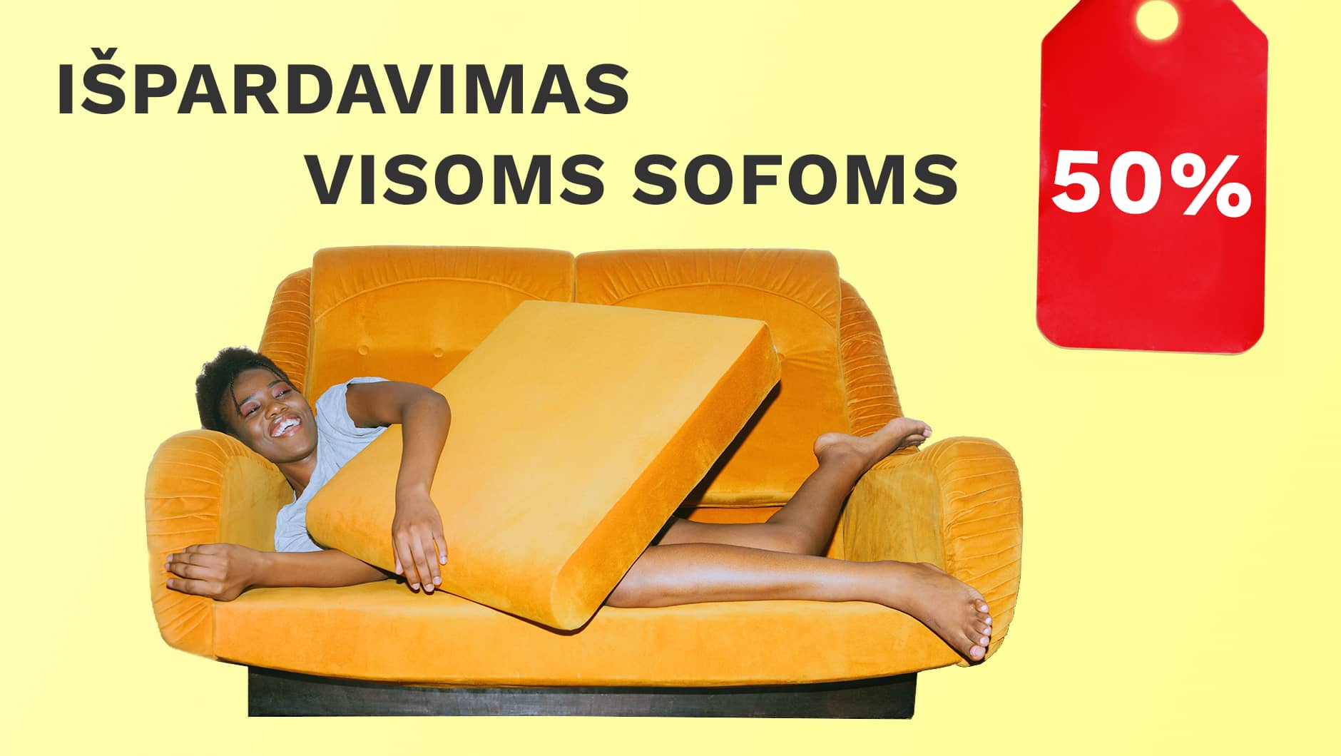 Laiminga panelė guli ant oranžinės sofos